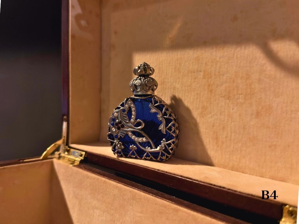 Decorative blue and silver oil perfume bottle with a decorative stingray
