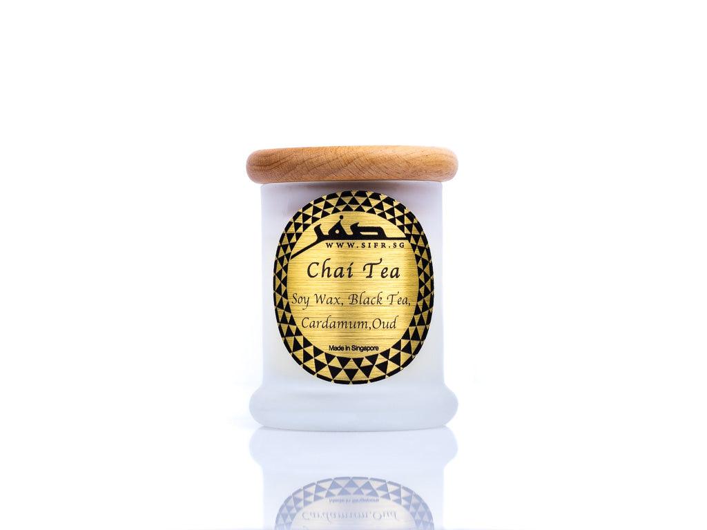 Small 'Chai Tea' candle in a white container with a wooden lid. The gold label with black text reads 'Chai Tea, Soy Wax, Black Tea, Cardamom, Oud,' and features the Sifr Aromatics logo in black